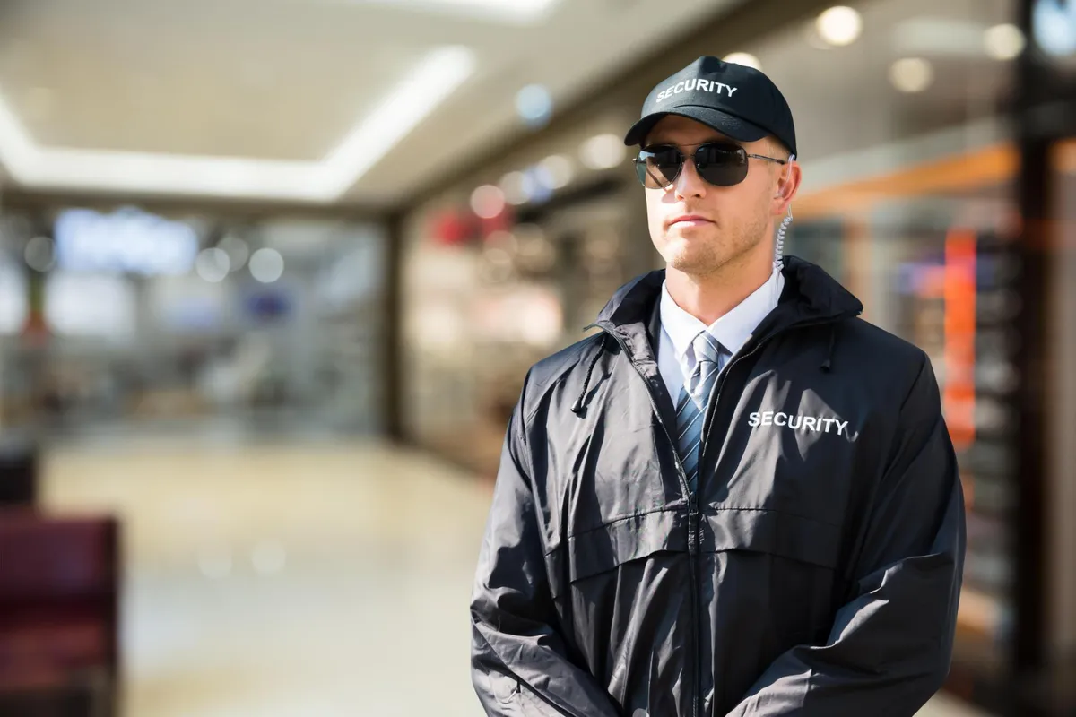 Uniformed security guard watching a building entrance