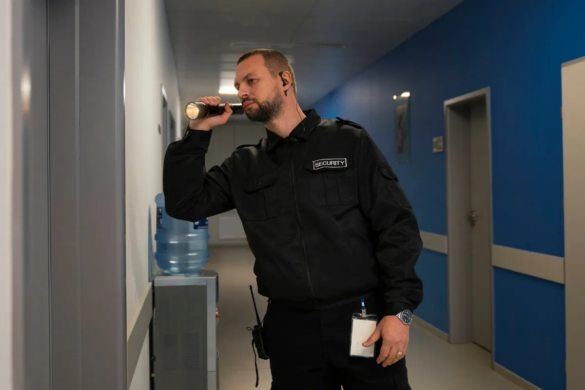 Security guard checking a corridor with a torch